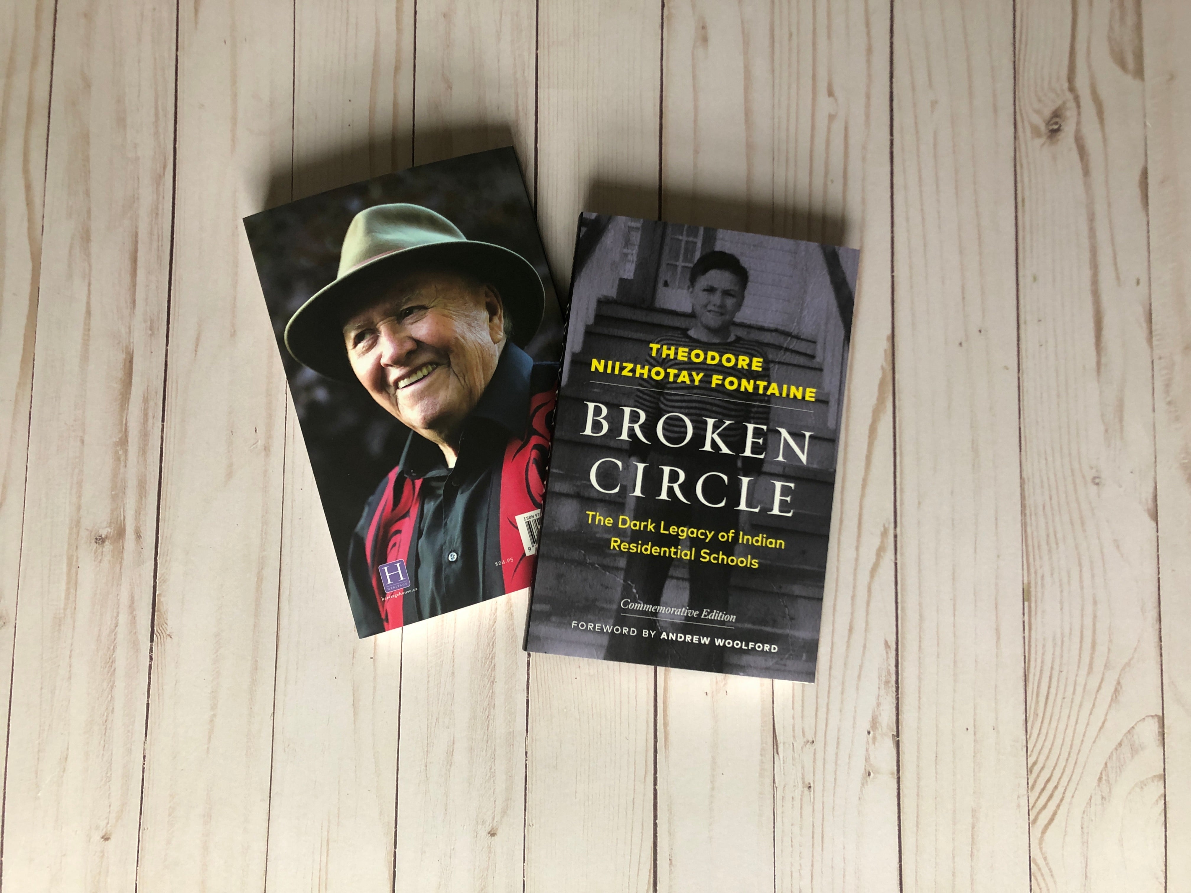 a copy of Broken Circle lays next to a photo of the author, against a wooden background